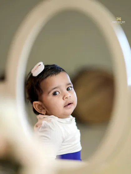 A sweet sitter session moment. This baby girl's curious expression is perfectly captured in the reflection of a mirror.
