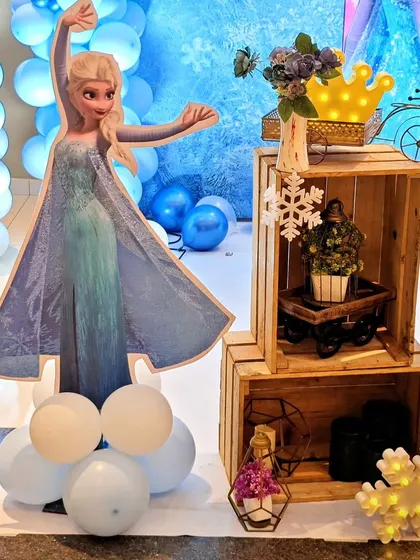 A life-size Elsa cutout stands next to a decorative crate display, creating a perfect photo spot.