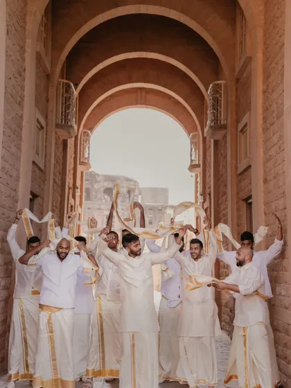 The groom's squad, dressed in traditional South Indian attire, making a grand entrance through the palace corridors. We capture the energy and excitement of the groom's side.