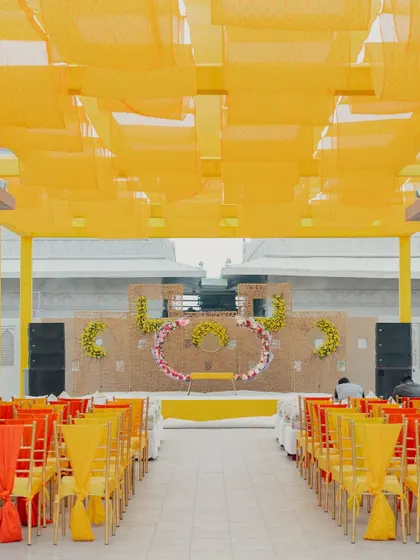 A vibrant and sunny Haldi ceremony setup at the Fairmont Jaipur. The bright yellow drapes and floral arrangements create a joyful and energetic atmosphere, perfect for pre-wedding festivities.