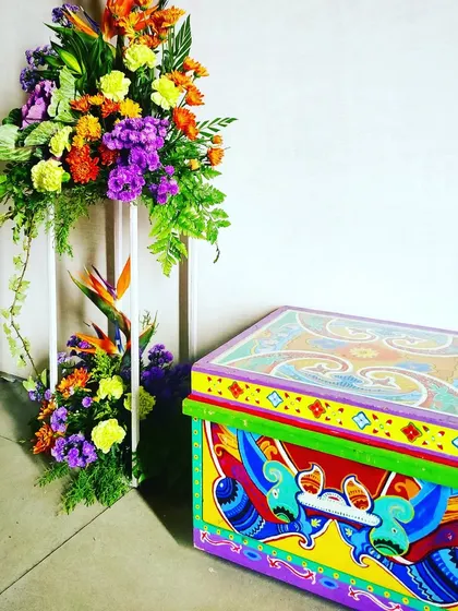A quirky, hand-painted trunk and a vibrant floral arrangement added a personalized and artistic touch to the 'Colour Pop' birthday brunch, reflecting the client's personality.