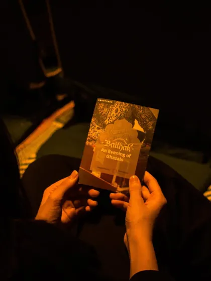 A guest holds the program for an evening of ghazals. It’s these little details that make the experience special, setting the tone for a night of beautiful music.