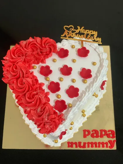 A heart-shaped anniversary cake for "Papa Mummy". The cake is decorated with red buttercream rosettes and delicate piping.