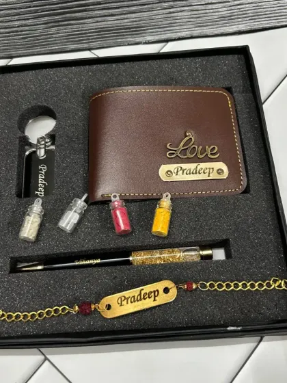 A personalized gift set for Rakhi, featuring a wallet, keychain, pen, and bracelet, all customized with the name 'Pradeep'. The set includes small bottles for roli and chawal.