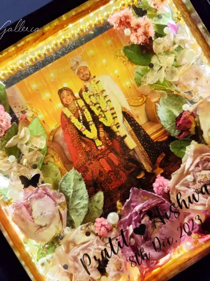 A close-up of the lighted wedding frame, showing the beautiful details of the preserved flowers under the warm light.