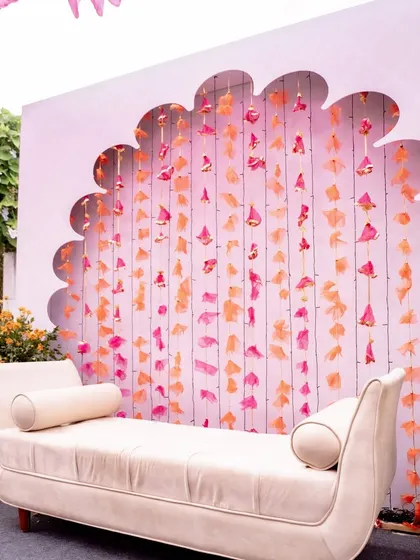A close-up of the elegant Mehendi backdrop, with its clean lines, hanging tassels, and comfortable seating for the bride.