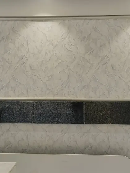 This bedroom wall combines a soft, marble-like texture with decorative patterned panels. This mixed-media approach adds layers of visual interest and a custom, high-end feel to the space behind the bed.