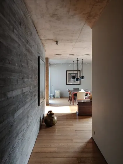 An interior corridor in the Jenga House, where a plank-shuttered concrete wall runs alongside a warm wooden floor. This juxtaposition of materials is a recurring theme in my work.