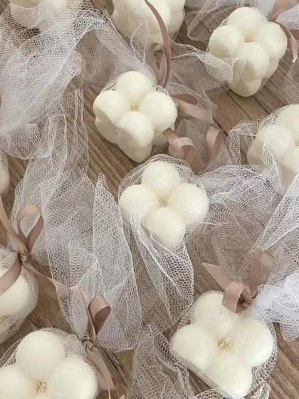 Another packaging option for the bubble candles, using a net potli with a neutral-colored ribbon.