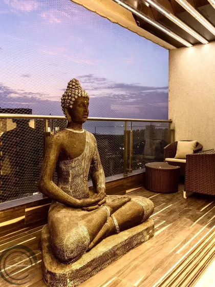 What could be better than a gorgeous balcony with a beautiful Buddha statue? This space is designed for calm reflection, with a comfortable seating area and a view of the evening sky.