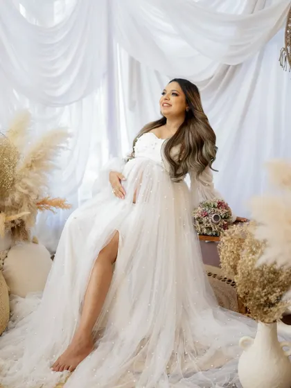 A joyful and radiant portrait. The mom-to-be is surrounded by the soft, natural elements of my boho studio setup, her smile lighting up the frame.