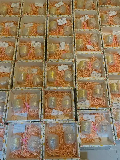 An overhead view of the wedding favor boxes, showing the consistent and careful packing of each gift.