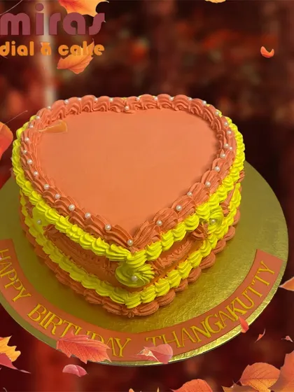 A simple and sweet heart-shaped cake in shades of orange and yellow. The layered piping and pearl details make it a lovely choice for a heartfelt birthday wish.