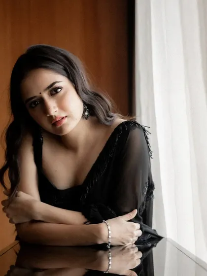 This is my take on the classic black saree. It's a pure georgette saree with subtle, delicate embroidery and handmade dangling details on the edges for a touch of understated elegance.