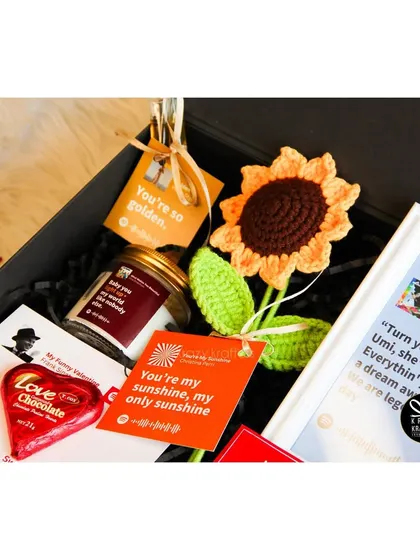 A close-up on the personalized tags and candle in the 'Tunes of Love' hamper.