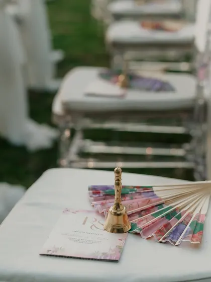 A small bell and a fan placed on each guest's seat at the ceremony. The bell was to be rung when the couple exchanged varmalas.