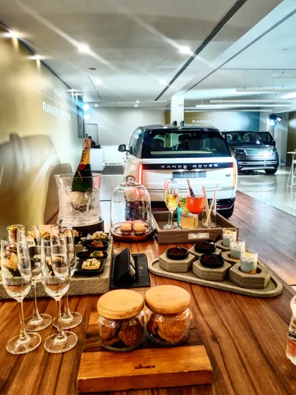A wide view of our setup for the Range Rover launch, showcasing the elegant food and beverage display in front of the new vehicle. We create a complete sensory experience that elevates the product reveal.