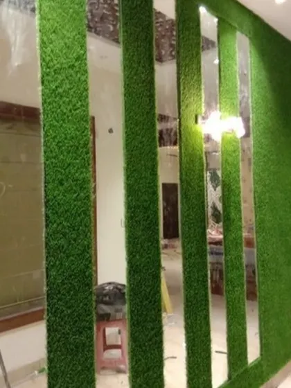 I used artificial grass to create a unique room partition, alternating green panels with full-length mirrors. This design not only divides the space but also makes it feel larger and brighter.