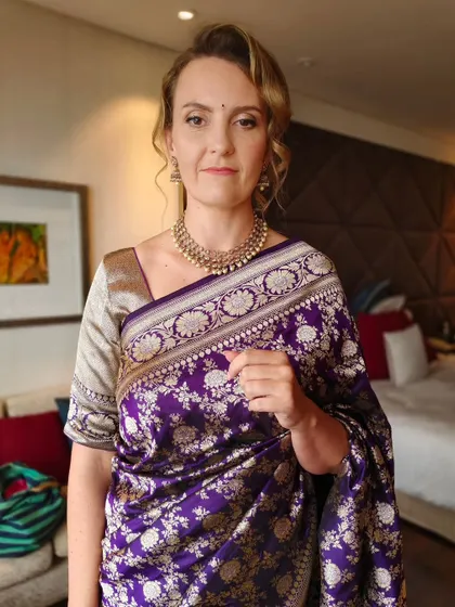 A full view of her look. The purple saree is beautifully complemented by the soft, neutral tones of her makeup.