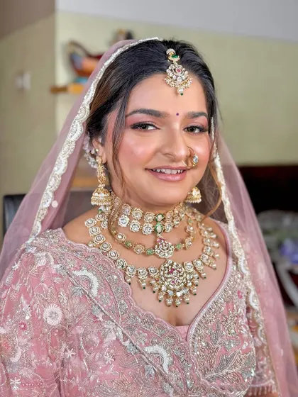The final look for this bride in her pastel pink lehenga, complete with a veil and radiant, dewy makeup.