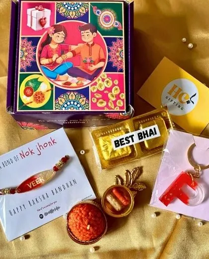 A compact Rakhi gift set with a personalized rakhi, a 'Best Bhai' chocolate, a custom initial keychain, and a decorative candle.
