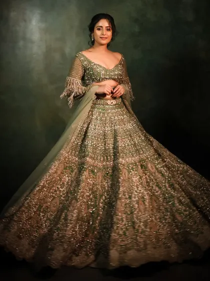 A grand, sweeping shot of this stunning festive lehenga. The makeup is designed to be glamorous and camera-ready, perfect for capturing the magic of the moment.