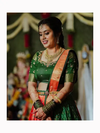 A beautiful portrait of the bride in her half-saree, her shy smile and elegant posture perfectly captured.