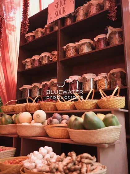 A 'Spice Souk' setup, with shelves of colorful spices in jars and baskets of fresh produce, creating an authentic and interactive market stall for guests.