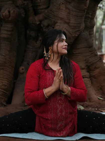 A close-up portrait in a meditative pose, finding stillness and connection outdoors.