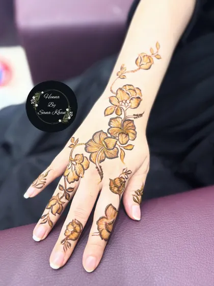 A single, elegant floral vine on the back of the hand. This minimalist approach is perfect for modern tastes and smaller events.