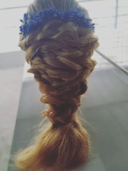 A soft and romantic messy fishtail braid, topped with a delicate blue floral crown. This bohemian-inspired hairstyle is perfect for outdoor pre-wedding photoshoots or a relaxed party look.