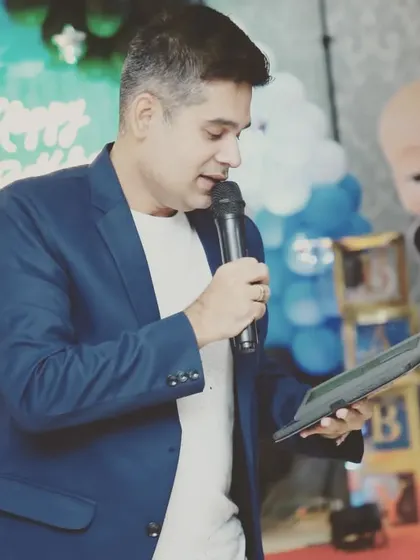 A professional shot of me on the mic at a Boss Baby themed birthday party.