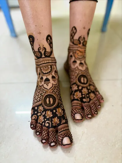 Matching feet mehendi for a baby shower, with peacock and lotus motifs to complete the festive look.
