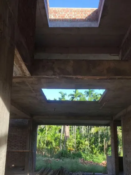 A home in an areca farm under construction. Skylights are strategically placed to frame views of the sky and the palm trees.