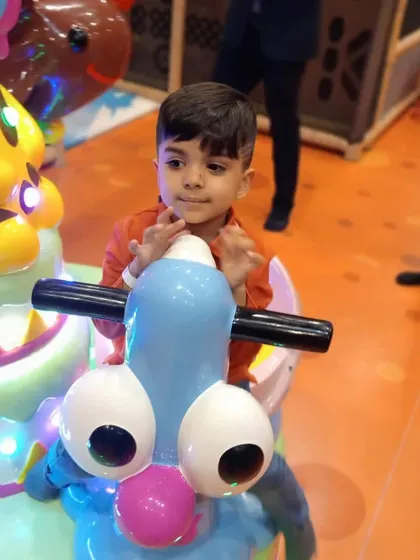 Taking the wheel on one of our fun, light-up rides. These are perfect for our younger visitors to enjoy a gentle and exciting carousel-style experience.