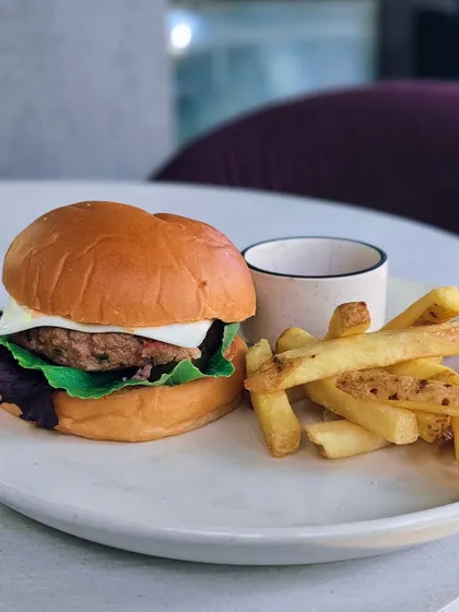 A classic cheeseburger, simple but executed perfectly. A juicy patty with melted cheese and fresh greens.
