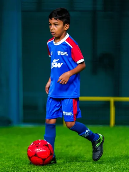 A young player shows intense focus while dribbling through cones. Discipline and concentration are key skills we develop in every session.