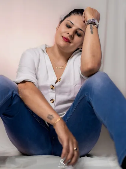 A relaxed moment during the photoshoot. The combination of a simple white shirt, blue jeans, and red lipstick is effortlessly chic.