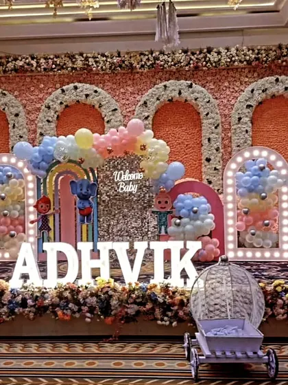 I design large scale, themed birthday parties for kids that bring their favorite characters to life. This Cocomelon stage setup for Adhvik's welcome party includes character cutouts, marquee letters for the name, and multiple balloon-filled arches for a grand entrance.