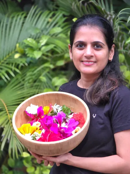 My wife holding the bowl of freshly plucked flowers for our pooja. The garden provides for us in so many ways.