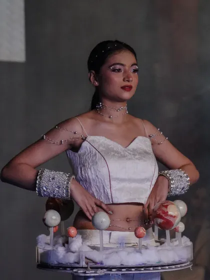 A model showcases a creative costume designed to look like the solar system.