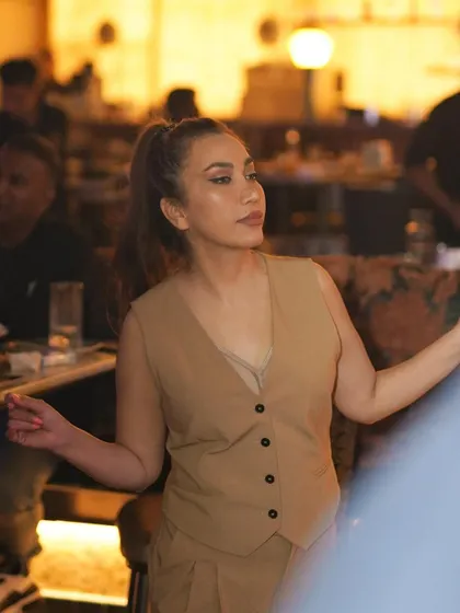 A guest looking elegant in a beige vest, enjoying the sophisticated atmosphere.