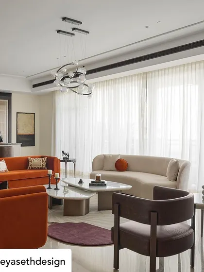 In collaboration with Sreya Seth Design, we crafted furniture for this elegant living room. The space features a vibrant orange sofa that brings a pop of color, balanced by a gracefully curved sofa in a neutral tone. The organic shapes of the marble-topped coffee tables add a sculptural element to the room.