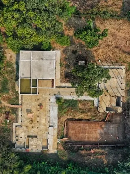 A top-down drone view of the Awas site, showing the footprint of the new structure in relation to the existing well and vegetation.