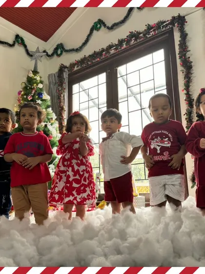Our toddler group stands in the "snow," dressed in their festive red outfits for the Christmas party.