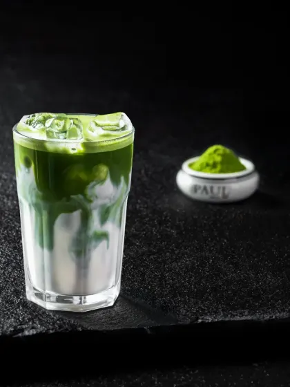 A simple yet elegant iced matcha latte, showing the swirl of green matcha into white milk.
