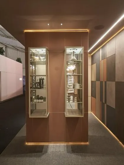 A corridor within the WALTZ 2024 exhibit, showcasing different wall panel finishes and lighting effects. The design creates a journey of discovery, where each turn reveals new materials and applications, telling the brand's story through texture and light.