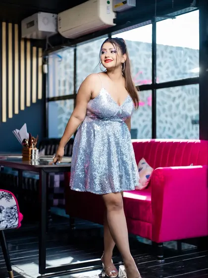 A bright and happy party look. The silver sequin dress, high ponytail, and classic glam makeup with a red lip create a timeless and celebratory style.
