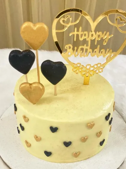 Even mini cakes can make a big statement. This one is decorated with black and gold hearts and a custom topper, making it a perfect personalized gift or a treat for a small celebration.