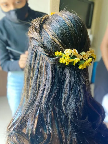 A close-up of the twisted braid and floral arrangement in this Haldi hairstyle.